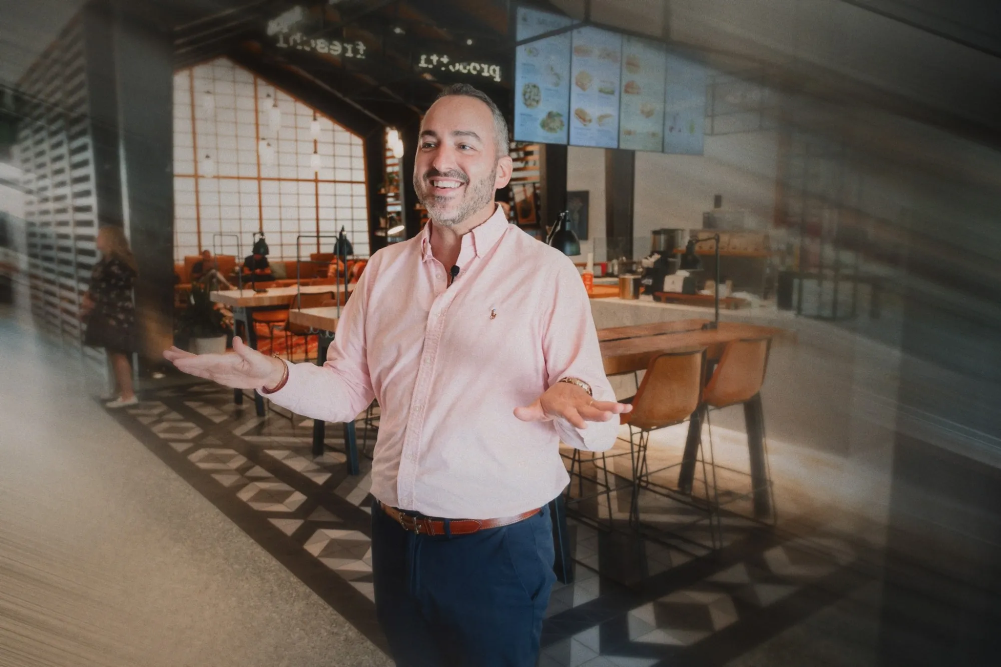 Frank McAdams gesturing mid-conversation in a Veris Residential café and lounge